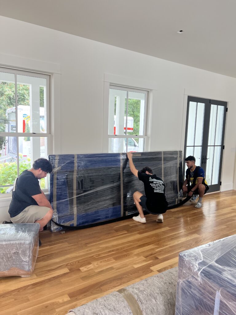 Three Elite Haulerz Movers moving a table